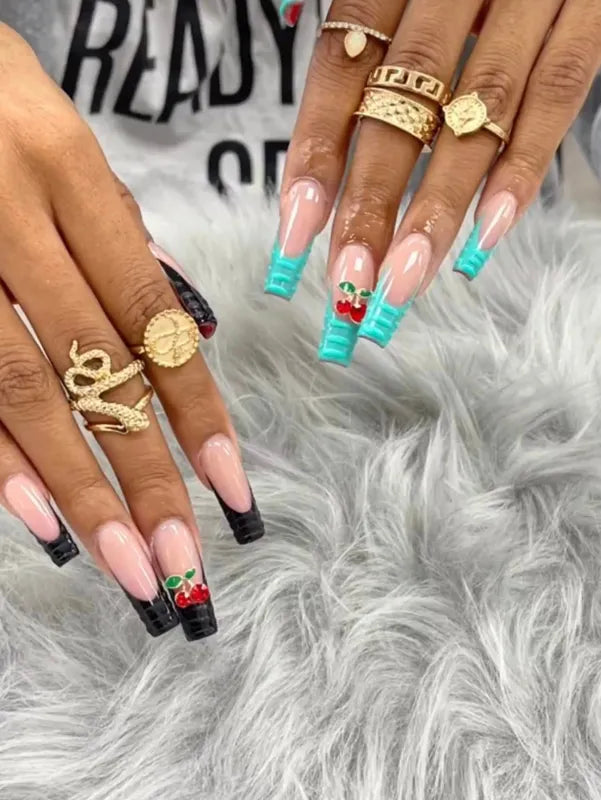 Cherry-topped acrylic nails with black and turquoise stripes from Nail Shadow.