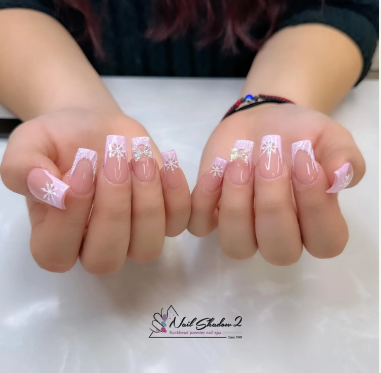 White snowflake nail art on clear acrylics by Nail Shadow for winter styles.